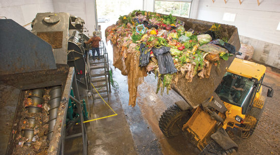 digester Food waste being loaded into a processing machine for anaerobic digestion.