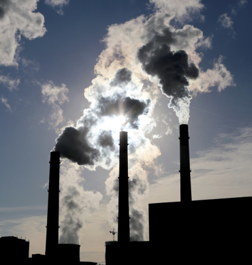 Smokestacks spewing out greenhouse gasses from a fossil fuel power plant.